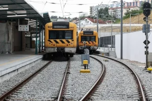 Comboios parados junto a uma plataforma.