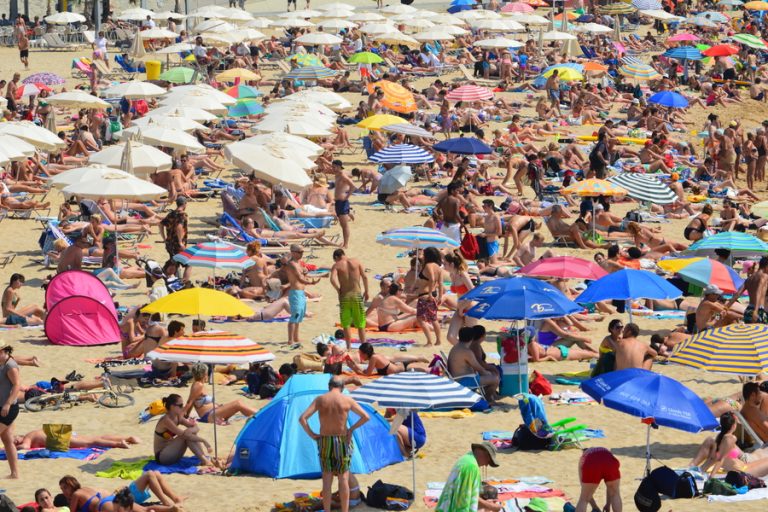 Praia cheia de turistas- Crédito: Freepik