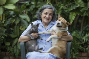 Mulher a segurar um cão e um gato. Crédito: Freepik AI